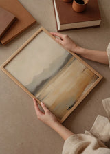 Wandbild mit sanften Bergen im Hintergrund, leuchtender Wasserfläche in Gold, Beige, Grau und Sand, im Natur- und modernen Landschaftsstil gestaltet. Erhältlich auf kudeko.com