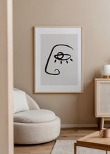 Quadro emoldurado com rosto abstrato, olho central destacado, linha preta contínua sobre fundo bege claro, num estilo abstrato de formas depuradas e contemporâneas. Disponível em kudeko.com