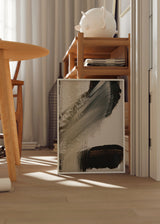 Tableau abstrait encadré avec larges traits diagonaux en noir, gris fumée, beige et blanc cassé, dans un style contemporain équilibré et sobre. Disponible sur kudeko.com