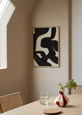 Quadro emoldurado com formas abstratas pretas, linhas curvas e largas sobre fundo branco, contraste marcado e estilo contemporâneo depurado na decoração de parede. Disponível em kudeko.com