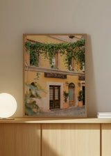 Wandbild mit Fassade eines Restaurants in Rom, gelben Wänden, Holzfenstern, klassischen Laternen, grünen Rankpflanzen und fotografischem Stil mit mediterranem Charakter. Erhältlich auf kudeko.com