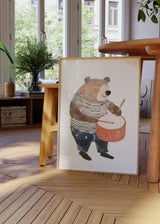 Gerahmtes Wandbild mit kindlichem Bären an einer orangefarbenen Trommel, weiß-blau gestreifter Kleidung, Beige, Braun, Marineblau und sanftem Kinderstil. Erhältlich auf kudeko.com