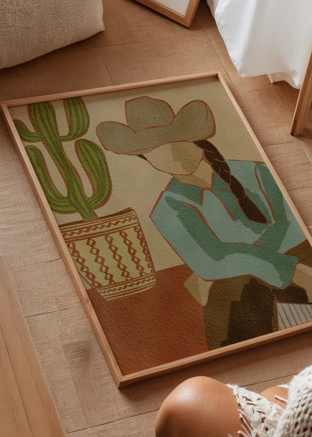 Dekoratives Wandbild im minimalistischen Stil mit Illustration in einem Wohnzimmer, Wüsten-Cowgirl mit Kaktus in warmen Farbtönen, Modell Desert Cowgirl and Cactus. Erhältlich auf kudeko.com