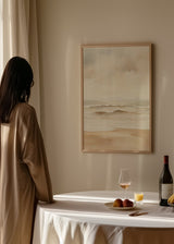 Gerahmtes Wandbild mit ruhiger Strandszene, sanften Wellen, beigem Sand, diesigem Himmel und verschwommenem Horizont in Creme, Hellgrau und Sandtönen, im Natur- und Landschaftsstil. Erhältlich auf kudeko.com