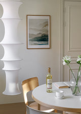 Tableau encadré avec paysage de montagnes en couches, brume légère, phrase inspirante blanche, tons beige, gris doux, vert pétrole et bleu sourd, style typographique contemporain. Disponible sur kudeko.com