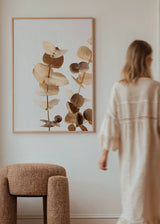 Tableau encadré avec branches d’eucalyptus, feuilles arrondies beige, crème et brun doux, fond clair et style botanique floral raffiné. Disponible sur kudeko.com