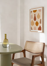 Tableau encadré avec composition de vases et poteries aux formes organiques, en terracotta, beige, sable et brun doux sur fond crème, dans un style minimaliste. Disponible sur kudeko.com