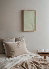 Quadro emoldurado com folhas de ginkgo em linhas finas sobre fundo creme, tons de bege e verde muito claro, composição botânica de estilo floral delicado. Disponível em kudeko.com