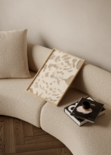 Cuadro decorativo de estilo minimalista y orgánico colocado en salón, composición abstracta orgánica en tonos arena, modelo Rastro Menudo