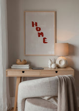 Wandbild mit dem Wort HOME in bordeauxfarbenen Buchstaben auf beigem Hintergrund, klarer dekorativer Stil für ein warmes Zuhause. Erhältlich auf kudeko.com