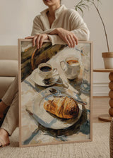 Quadro minimalista que captura um instante de tranquilidade com café e um croissant. Disponível em kudeko.com.