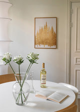 Gerahmtes Wandbild mit Silhouetten eines Tannenwaldes in Gold auf weißem Hintergrund, klare Komposition, helle Farben und zeitgenössischer Natur- und Landschaftsstil. Erhältlich auf kudeko.com
