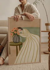 Wandbild im minimalistischen und ruhigen Stil in einem Wohnzimmer, Frau betrachtet Blumen in einer Vase, Modell Woman Admiring Flowers. Erhältlich auf kudeko.com