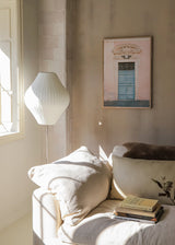 Wandbild mit alter pastellblauer Tür vor puderrosa Fassade, klassischen Stuckdetails, Ziergitter und urbaner Bildsprache im fotografischen Stil. Erhältlich auf kudeko.com