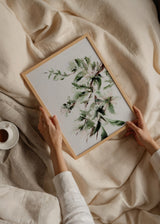 Tableau de fleurs ouvertes et branches délicates en vert sauge, blanc cassé, noir doux et brun rougeâtre, dans un style floral léger sur fond clair. Disponible sur kudeko.com
