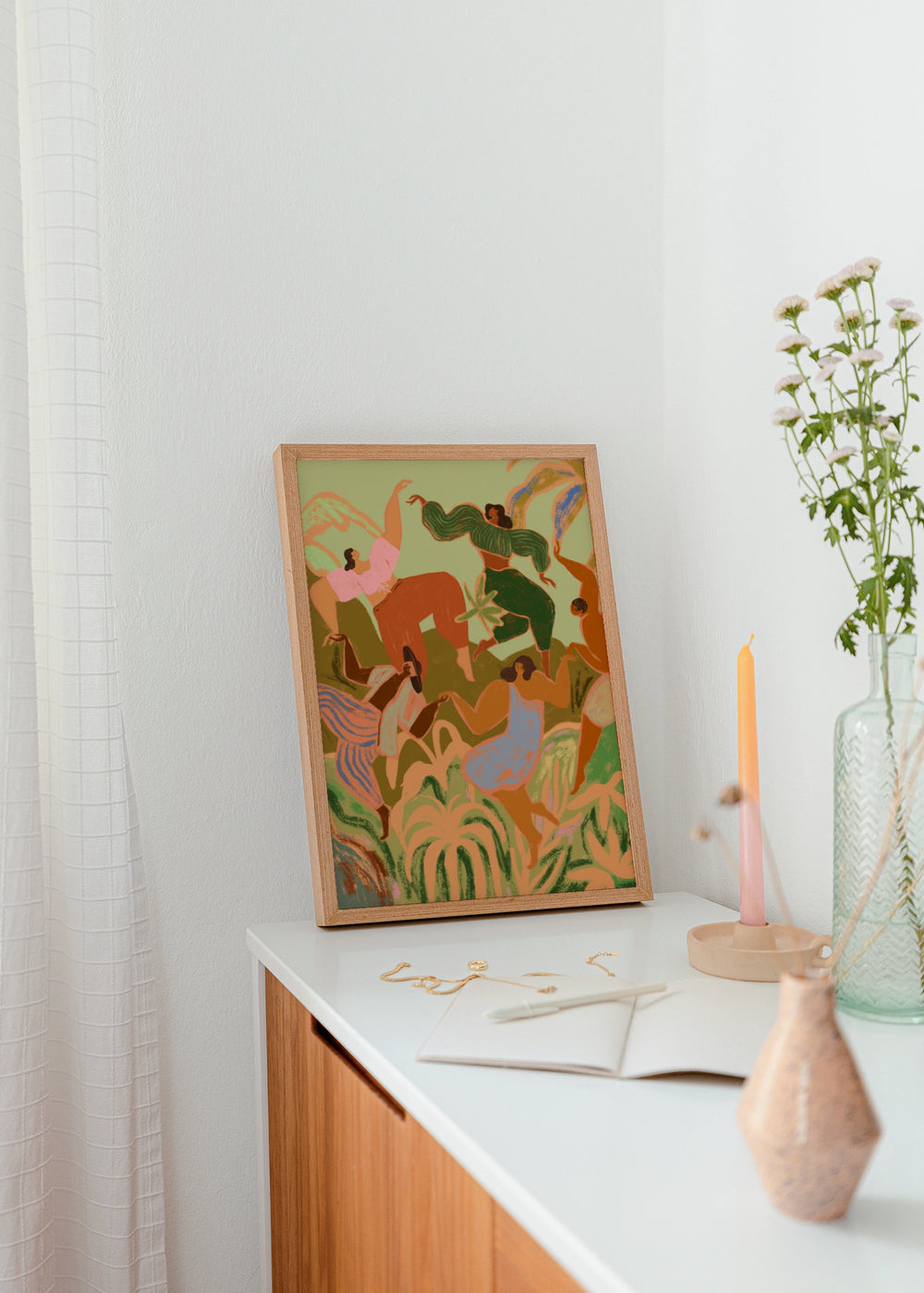 Quadro decorativo em tons pastel e estilo orgânico colocado numa sala de estar, mulheres a dançar entre flores primaveris, modelo Spring Frolic. Disponível em kudeko.com