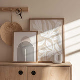 Cuadro de hojas y formas florales blancas sobre fondo beige arena, con siluetas orgánicas amplias y estilo minimalista. Disponible en kudeko.com