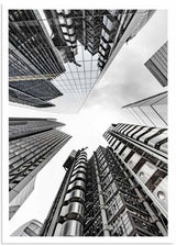 Wandbild mit Wolkenkratzern in aufsteigender Perspektive, Glas- und Stahlfassaden, urbanen Linien in Weiß, Schwarz und Grau, im modernen architektonischen Stil. Erhältlich auf kudeko.com