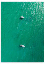 Wandbild mit Luftaufnahme eines türkisfarbenen Meeres, zwei kleinen weißen Booten auf dem Wasser, sanften Spiegelungen und fotografischem Stil. Erhältlich auf kudeko.com