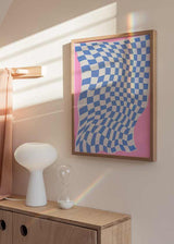 Quadro com padrão de quadrados ondulados em azul claro e branco, formas curvas cor-de-rosa e estilo geométrico moderno com sensação de movimento. Disponível em kudeko.com