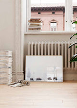 Quadro horizontal com quatro bisontes num campo nevado, árvores difusas entre a névoa, tons brancos, cinzentos e castanhos, em estilo fotográfico de ambiente invernal. Disponível em kudeko.com