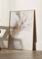 Tableau avec composition abstraite aux formes fluides en blanc cassé, gris doux et détails dorés à l’aspect minéral, style abstrait contemporain et décoration murale encadrée. Disponible sur kudeko.com