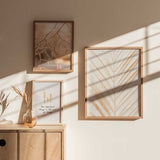 Cuadro de hoja de palma simétrica en tonos beige, arena y dorado suave sobre fondo blanco, de estilo minimalista. Disponible en kudeko.com