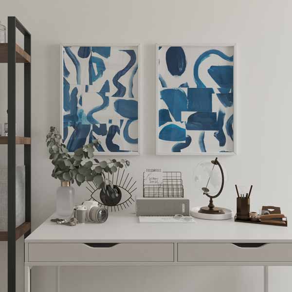 Conjunto de dois quadros com formas abstratas curvas, blocos irregulares em azul índigo, azul petróleo, azul claro e branco, de estilo abstrato contemporâneo. Disponível em kudeko.com