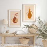 Cuadro con jarrón bohemio terracota, hojas estilizadas, formas orgánicas beige y acentos mostaza sobre fondo crema, de estilo minimalista. Disponible en kudeko.com