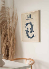 Cuadro con dos peces koi azul oscuro en composición circular, fondo beige texturizado y tipografía superior, de estilo ilustración. Disponible en kudeko.com