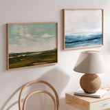 Cuadro horizontal de paisaje abierto con cielo azul verdoso, nubes claras, horizonte lejano y campos en tonos tierra y oliva, de estilo naturaleza y paisajes. Disponible en kudeko.com