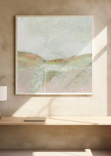 Tableau carré avec paysage abstrait de collines douces, bande lumineuse centrale, ciel clair, beige, rose poudré, crème et vert sauge, style nature et paysage épuré. Disponible sur kudeko.com