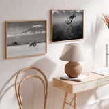 Horizontales Wandbild mit einem einzelnen Elefanten in der Savanne, schneebedecktem Berg im Hintergrund, tiefen Wolken sowie Grau-, Weiß- und Schwarztönen im fotografischen Stil. Erhältlich auf kudeko.com