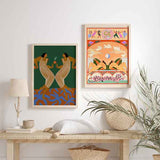 Cuadro de dos figuras femeninas simétricas con vestidos claros, fondo verde oscuro, suelo marrón y hojas azules, de estilo ilustración. Disponible en kudeko.com