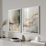 Quadro com composição abstrata de formas fluidas em bege, areia, cinza claro e taupe suave, com aparência etérea e estilo abstrato contemporâneo. Disponível em kudeko.com