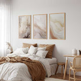 Quadro com composição abstrata de formas fluidas em creme, bege, areia e cinzento fumado, com apontamentos escuros e estilo abstrato depurado. Disponível em kudeko.com
