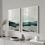 Conjunto de dos cuadros con montañas suaves al fondo, horizonte despejado, terreno en azul petróleo, blanco roto, beige y negro, de estilo abstracto. Disponible en kudeko.com