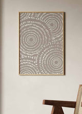 Cuadro con círculos concéntricos y formas curvas repetidas en blanco sobre fondo beige grisáceo, de estilo abstracto. Disponible en kudeko.com