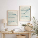 Wandbild mit feinen geschwungenen Linien in Graublau auf elfenbeinfarbenem Hintergrund, abstraktem Motiv und minimalistischem Stil für eine ruhige ausgewogene Wandgestaltung. Erhältlich auf kudeko.com