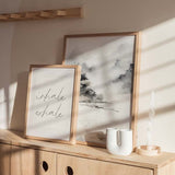 Tableau avec paysage abstrait de montagnes brumeuses, arbres sombres, rive paisible, tons gris, noir et beige clair, dans un style épuré et contemporain. Disponible sur kudeko.com