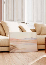 Cuadro horizontal de paisaje lacustre con montañas suaves al fondo, reflejos en agua tranquila, tonos arena, melocotón, beige y gris lavanda, estilo naturaleza y paisajes. Disponible en kudeko.com