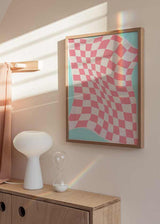 Cuadro con patrón ajedrezado ondulado en rosa pastel y blanco, con bordes turquesa suaves y estilo geométrico de efecto óptico moderno. Disponible en kudeko.com