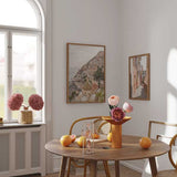Ensemble de deux tableaux avec ruelle italienne aux façades rosées et vue côtière d’un village en terrasses, dans des tons sable, terracotta, beige et bleu doux, au style photographique lumineux. Disponible sur kudeko.com