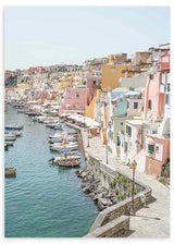 Quadro de porto costeiro com casas em tons pastel, barcos atracados, passeio junto ao mar, água azul esverdeada e estilo fotográfico mediterrânico. Disponível em kudeko.com