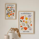 Ensemble de deux tableaux avec fleurs et feuilles décoratives en orange, jaune, lilas, rose et vert olive, style floral avec titres Flower Market de villes sur fond clair. Disponible sur kudeko.com