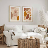 Cuadro de hojas botánicas lineales sobre fondo beige con formas orgánicas terracota y mostaza, de estilo minimalista. Disponible en kudeko.com