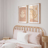 Set aus zwei Wandbildern mit übereinander angeordneten geschwungenen Formen und linearer botanischer Silhouette in Beige, Creme und sanftem Terrakotta, im minimalistischen Stil. Erhältlich auf kudeko.com