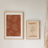 Cuadro con ramas y hojas en líneas color crema sobre fondo terracota cálido, composición botánica ligera de estilo floral. Disponible en kudeko.com