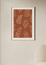 Cuadro con ramas de hojas en líneas color crema sobre fondo terracota cálido, composición botánica repetitiva de estilo floral. Disponible en kudeko.com