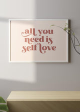 Horizontales Wandbild mit dem Schriftzug all you need is self love, Retro-Typografie in Terrakotta auf hellrosa Hintergrund, klarer Stil mit Textmotiv für Schlafzimmer oder Arbeitsbereich. Erhältlich auf kudeko.com